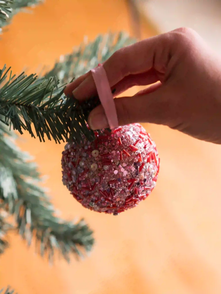 Flocked Christmas Tree Decorating Ideas with DIY ornaments including wooden baubles, pinecones, and ribbon bows