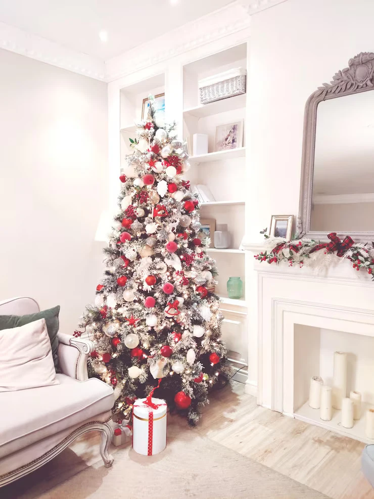 Minimalist red and white Christmas tree ideas with matte ornaments and white lights in a modern living room
